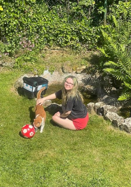 Beth Yvonne relaxing in the garden with her cat