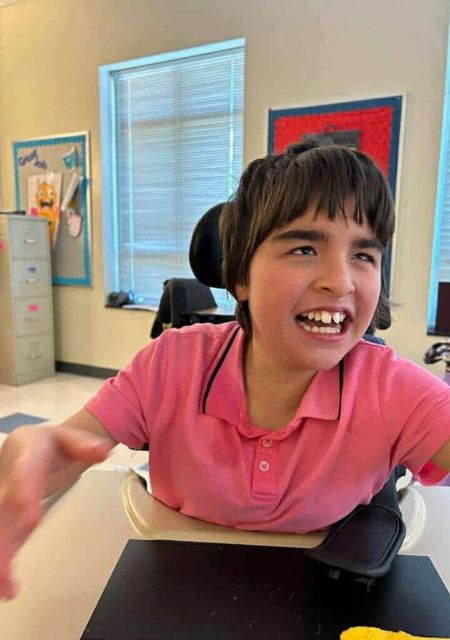 Happy young child Iris smiling in pink shirt sharing her epilepsy story