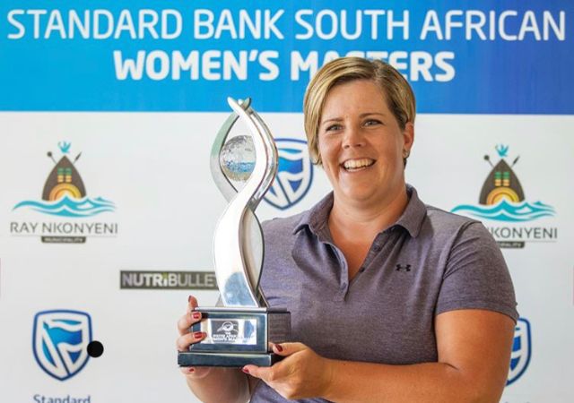 Golfer holding a trophy at the Standard Bank South African Women's Masters event.
