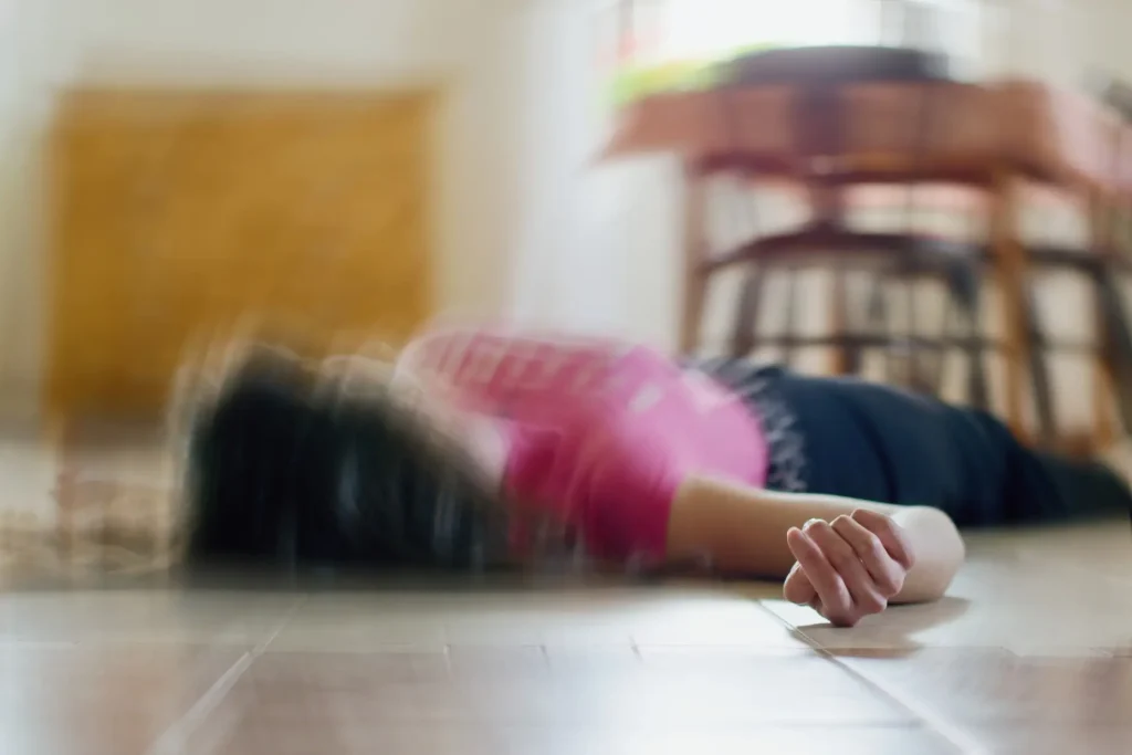 Young person lying on floor during epileptic seizure demonstrating what happens when a seizure occurs