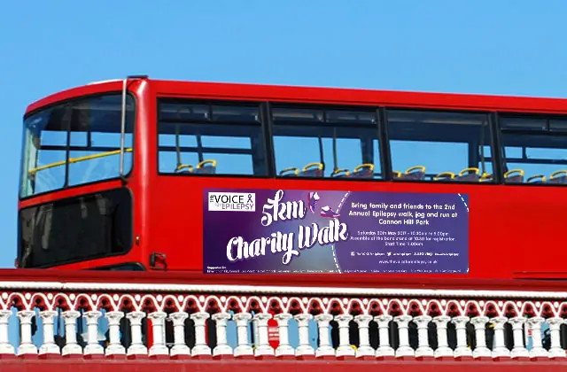 Red double-decker bus displaying charity walk advertisement for epilepsy