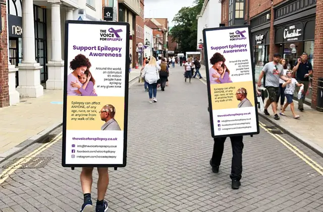 People wearing advertising boards promoting epilepsy awareness on a street