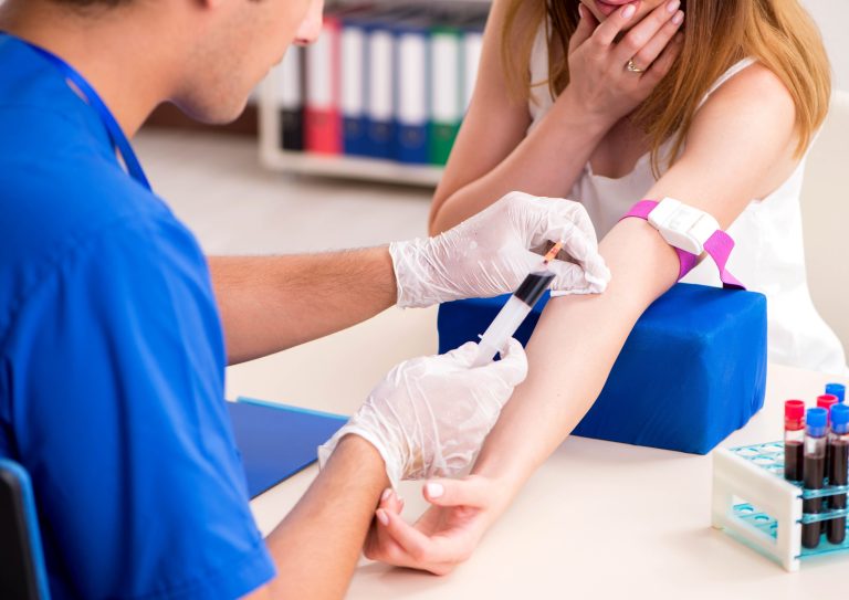 Young patient having blood test taken by healthcare professional for epilepsy diagnosis and monitoring