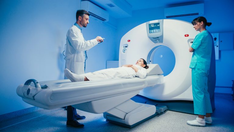 Patient entering MRI scanner machine with medical team for epilepsy brain imaging and diagnosis