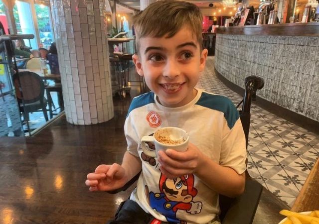 Young boy Caleb Mccarthy enjoying ice cream at cafe sharing his epilepsy story and journey