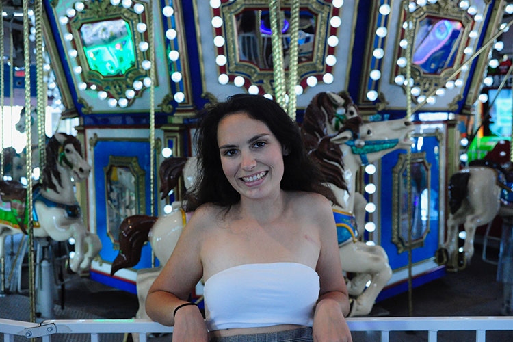 Addison Taylor smiling portrait at fairground carousel, enjoying life whilst living with epilepsy