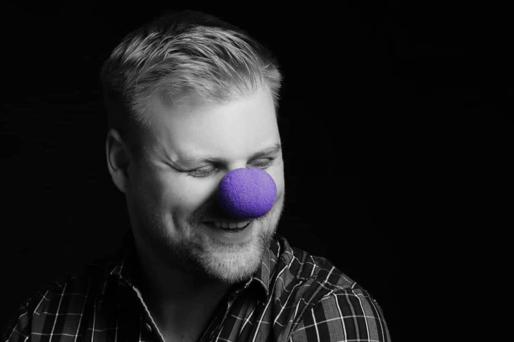 Man wearing purple nose in artistic black and white portrait for Purple Day epilepsy awareness