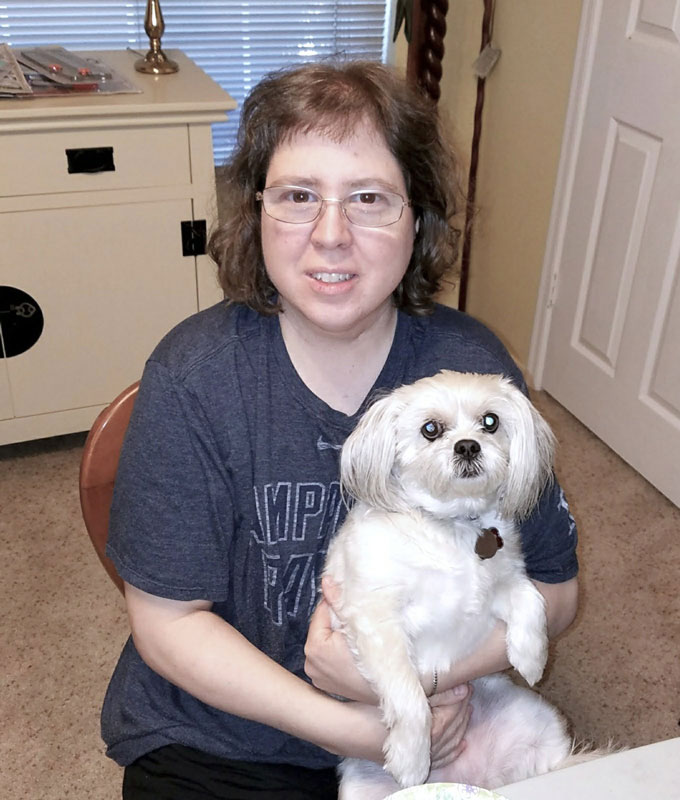 Nancy Young at home with her small white dog, sharing everyday life whilst living with epilepsy