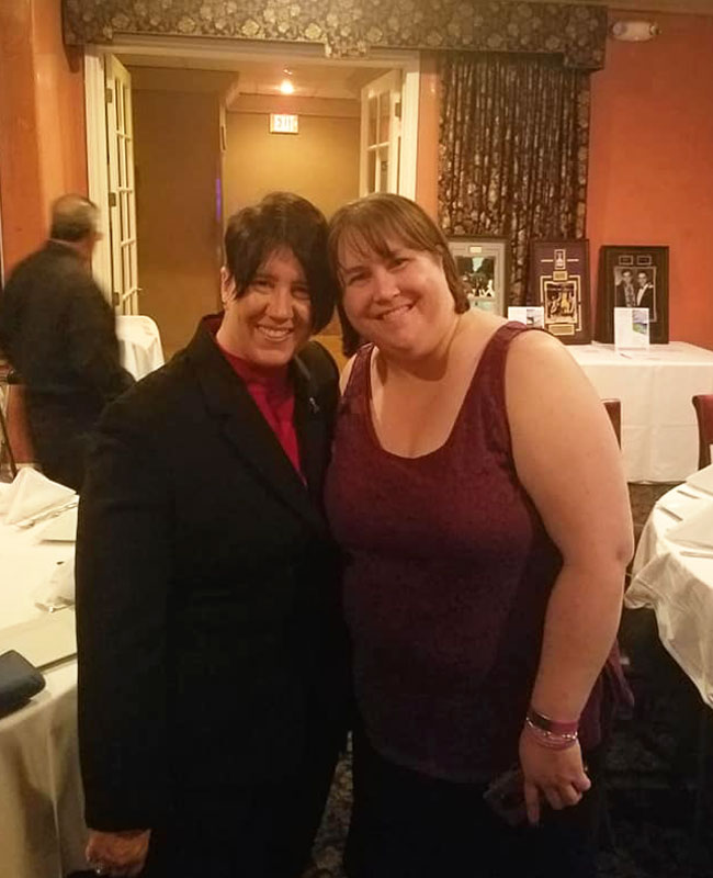 Natalie with friend at social event showing community support for people living with epilepsy