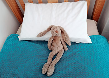 Child sleeping safely with anti-suffocation epilepsy pillow and stuffed toy for seizure protection at night